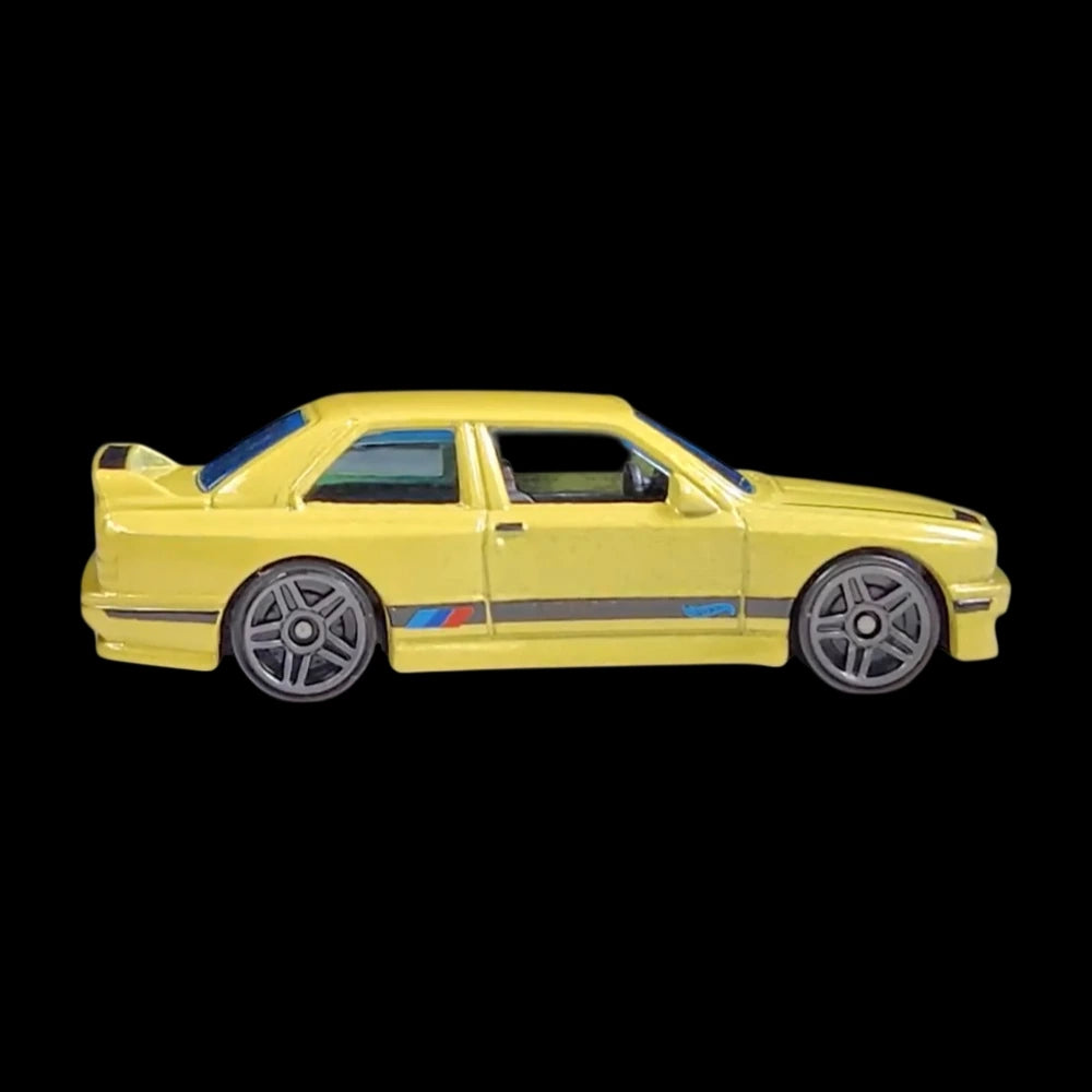 Hot Wheels 1:64 scale die-cast of the yellow '92 BMW M3 from HW: The '90s series with M stripe detailing.