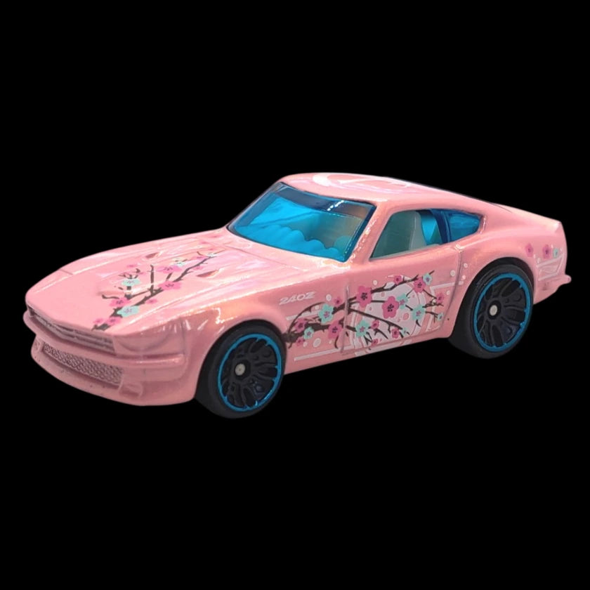 Hot Wheels 1:64 scale pink Datsun 240Z die-cast from the Art Cars series with floral designs.