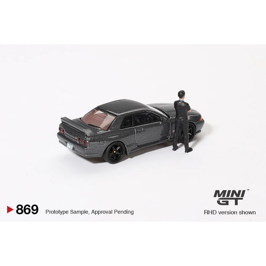 MiniGT 1:64 scale die-cast Nissan Skyline GT-R R32 in Gunmetal with Matsuda figure – model #869