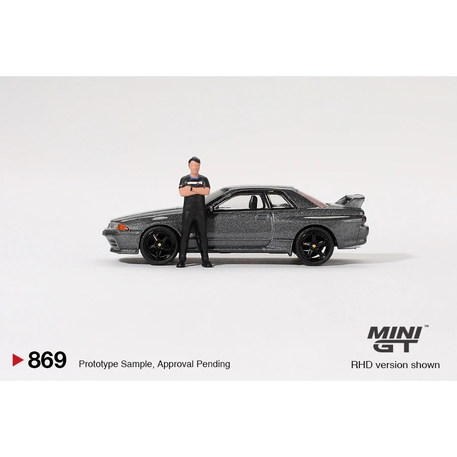 MiniGT 1:64 scale die-cast Nissan Skyline GT-R R32 in Gunmetal with Matsuda figure – model #869